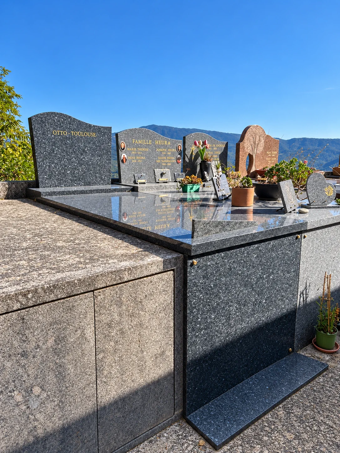 Ensemble de monuments en granit noir poli face aux montagnes